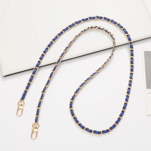 Detail of woven gold metal chain with navy blue leather strap and lobster clasps