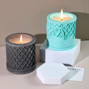 Velas aromáticas encendidas en soportes de celosía sobre pedestales minimalistas