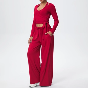 Détail d'un ensemble de yoga rouge avec haut cache-cœur à nouer et pantalon large à cordon
