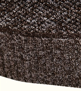 Macro detail of thick knit fabric texture on a brown and white half-zip sweater