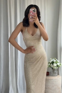 Close-up of champagne sequin halter neck dress with deep V-neckline and shimmer details