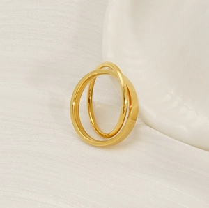 Close-up of golden double-band spinner ring on white textured fabric background