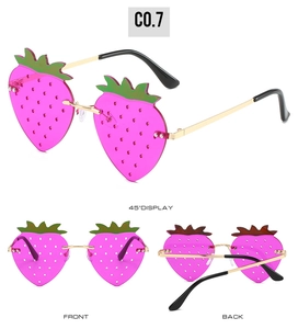 Detailed views of strawberry shaped sunglasses with pink lenses and metal frames
