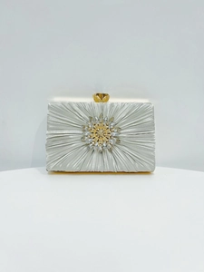 Detail der Seiden-Clutch mit Falten-Design, Sonnenblumen-Kristall und goldenem Verschluss