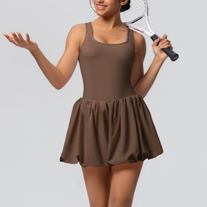 Detail view of brown tennis dress with U-neck tank top and pleated athletic skirt