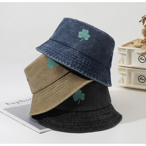 Three-color stack of cotton bucket hats with green shamrock embroidery detail