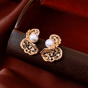 Macro shot of 18K gold plated lace flower earrings with pearl and crystal detail