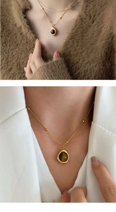 Detail of vintage golden snake chain with brown tiger eye stone pendant on clothing