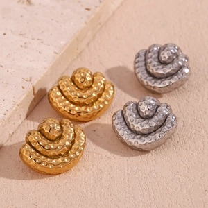 Close-up of hammered 18K gold and silver plated triple layer fan-shaped stud earrings