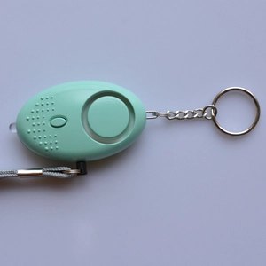 Mint green personal safety alarm with LED flashlight, silver keychain, and gray lanyard
