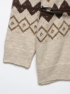 Detail of bohemian knit cardigan with geometric pattern, beadwork, and brown leather belt