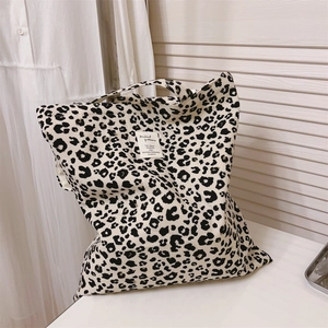 Detail of leopard print canvas tote bag with a white fabric label in a home setting