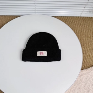 Close-up of black double-layer knit beanie featuring a white BAKE label for kids' winter warmth