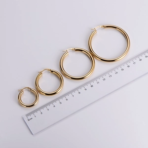 Polished 18k gold plated stainless steel hoop earrings in various sizes with ruler