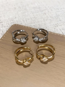 Detailed macro of gold and silver knotted hoop earrings with micro-pave cubic zirconia