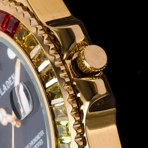 Macro shot of gold watch with multicolor gemstone bezel and black dial calendar detail