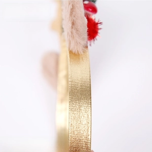 Detailed close-up of golden reindeer antler headband with plush ears and red berries