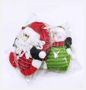 Detail showing Santa and Snowman plush dolls in transparent plastic retail packaging