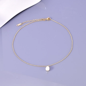 Close-up of gold-plated stainless steel chain with a single baroque pearl and K18 tag