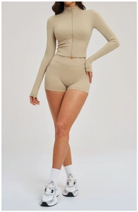 Detail of beige two-piece sports set with zip-up jacket and high waist shorts