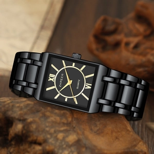 Detailed close-up of a rectangular black quartz watch with Roman numerals on a wood surface