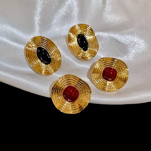 Detailansicht der Vintage-Ohrstecker in Gold mit Wellenstruktur und ovalen Steinen