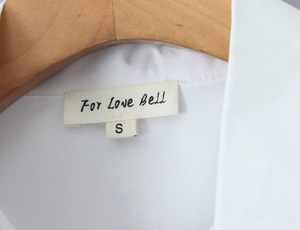 Close-up of a white puff sleeve blouse collar with size S label on a wooden hanger