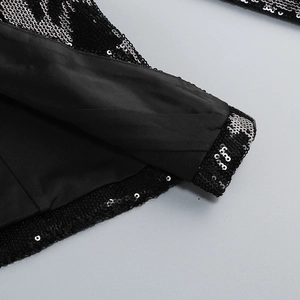 Gros plan des paillettes bicolores noires et argentées avec coutures de qualité sur la doublure