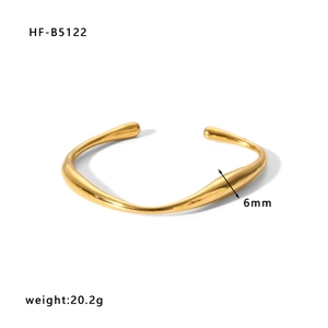 Detail view of gold wave-shaped open cuff bracelet showing 6mm width and 20.2g weight