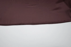 Macro shot of dark brown satin dress fabric featuring precise double-stitched sewing detail