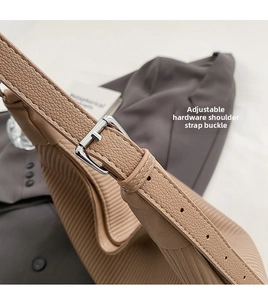 Détail de la bandoulière réglable avec boucle argentée et cuir à texture litchi