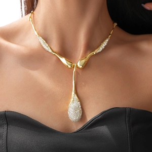 Close-up of a gold teardrop pendant necklace with rhinestones on a female model