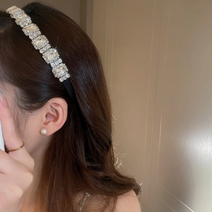 Dettaglio del cerchietto con grandi strass quadrati e orecchini di perle bianche coordinati