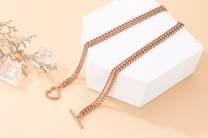 Detail of rose gold double layer Cuban chain necklace featuring a textured heart OT toggle