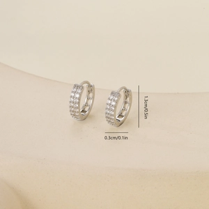 Macro detail of silver earrings with cubic zirconia and dimension labels of 1.3cm