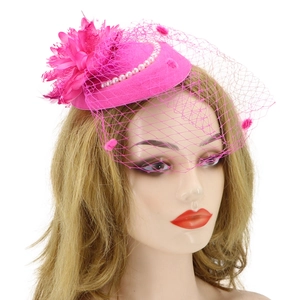 Detailed view of pink mesh fascinator with elegant feathers and white pearls