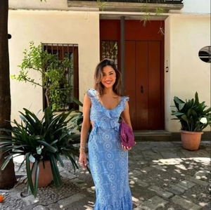 Blue heavy embroidery midi dress with cutout waist and ruffled layers on a female model