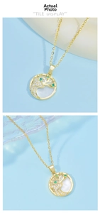 Close-up of golden stag necklace with white shell inlay and green gemstone detail