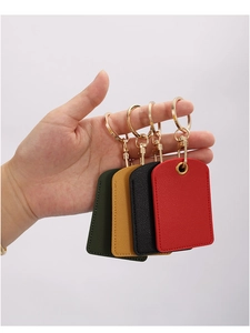 Detail of four colorful leather access card sleeves in dark green, yellow, black and red