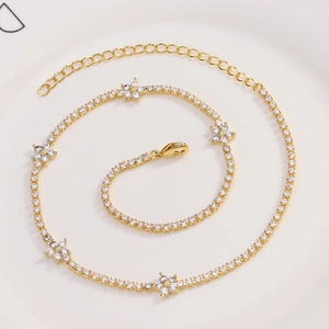 Detail of gold floral tennis anklet with zircon stars, lobster clasp and extension chain