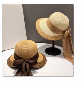 Detail of wavy brim straw hats with large elegant bows on a professional metal hat stand
