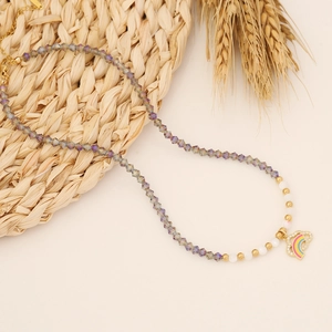 Rainbow heart pendant necklace with purple faceted beads on a natural straw mat