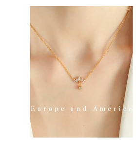 Detail of 18K gold-plated crown pendant necklace with sparkling white cubic zirconia stones