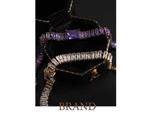 Lussuoso bracciale dorato con zirconi viola e bianchi taglio smeraldo in scatola nera