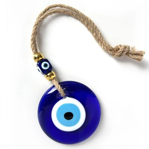 Detail view of a round blue glass Evil Eye pendant with jute rope and beaded accents