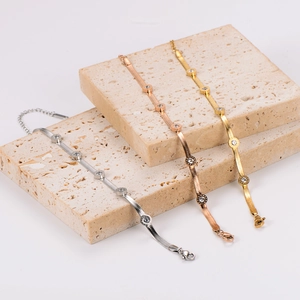 Flat snake chain bracelet with Roman numeral diamond pendant in gold, silver, and rose gold
