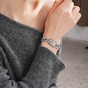 Close-up of sparkling silver Cuban chain bracelet with crystals on model's wrist