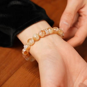 Détail d'un bracelet en perles de quartz jaune avec une perle sertie de zircon doré