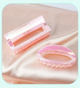 Detail of pink iridescent hair clips in rectangular and oval shapes on silk fabric