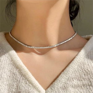 Close-up of minimalist silver tennis choker necklace with clear cubic zirconia on model